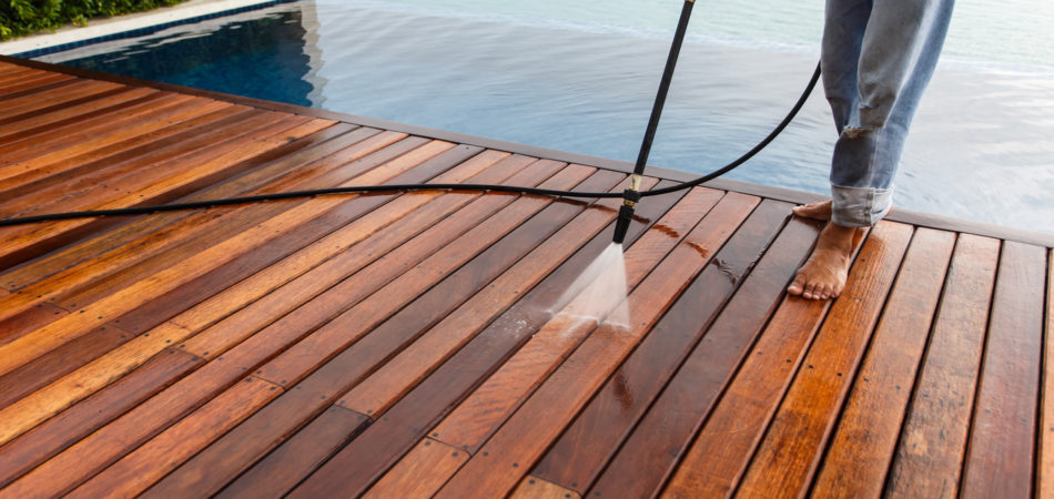 Thai man do a pressure washing on timber